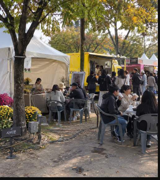 Food truck area alongside chrysanthemum sculptures at Gungnamji Pond during the Buyeo Chrysanthemum Festival